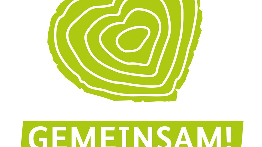 Das Bild zeigt einen Baumstammquerschnitt in Form eines grünen Herzes als Solidarisierungssymbol der Deutschen Waldtage.